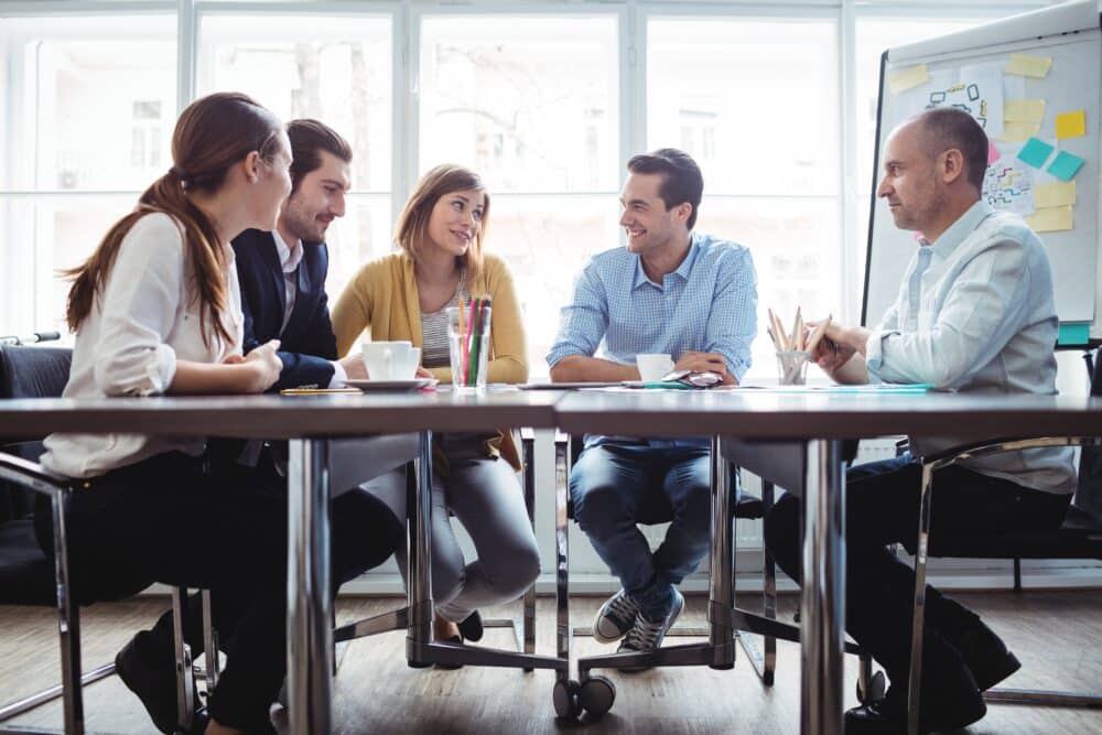 group of 5 professionals sitting around a conference table